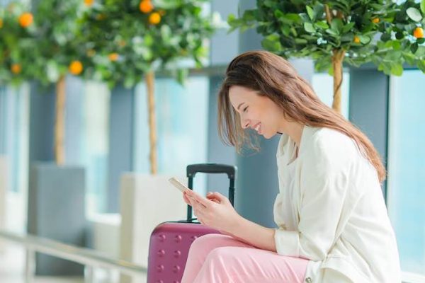 Young woman in international airport walking with her luggage.